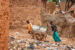Due ragazzi spingono una botte d'acqua in un sobborgo di Ouagadougou, Burkina Faso. E' uno  dei metodi più utilizzati per distribuire acqua agli abitanti - © MattLphotography ...
