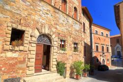 Edifici medievali in una strada soleggiata di Montepulciano, Toscana, Italia. La città è racchiusa da alte e imponenti mura.





