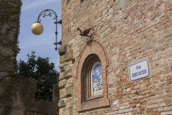 Elementi architettonici sulle mura di un edificio nel borgo di Certaldo, Toscana, Italia.
