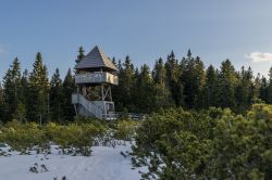 Escursione a piedi fra le montagne nei pressi di Rogla, Slovenia. Dalla torretta in legno immersa nei boschi si può ammirare il suggestivo panorama innevato.

