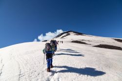 Escursionisti salgono sul vulcano Villarrica innevato, Pucon, Cile. La prima eruzione a memoria di uomo si è verificata nel 1558.
