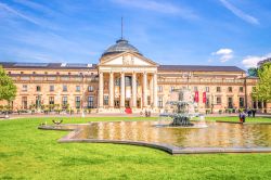 La facciata d'ingresso del Casinò di Wiesbaden con i suoi giardini e la fontana in una giornata di sole, Germania.
