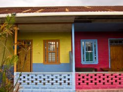 Facciate colorate con palme a San José, Costa Rica. Abitazioni decorate nelle tonalità del rosso e del giallo in questo angolo della capitale - © QArts / Shutterstock.com