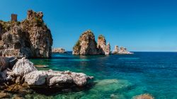 Faraglioni di Scopello, Sicilia: queste formazioni rocciose emergono dall'acqua cristallina del mare, proprio di fronte all'antica tonnara, caratterizzando l'intero paesaggio.
