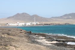 A sud di Fuerteventura, il Faro de punta Jandia in lontananza - Le scogliere piuttosto ripide ma anche le più tiepide scogliere e le pulite spiagge, contribuiscono a creare uno scenario ...
