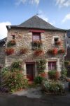 Fiori sulla facciata di una vecchia casa in pietra a Josselin, Francia.
