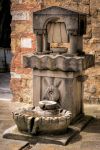 Fontana d'acqua potabile nel borgo di Castiglione del Lago, Umbria - Realizzata in pietra e ornata con belle decorazioni, l'acqua che scorre in questa fontana è potabile e vi ...