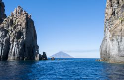 Formazioni rocciose a Panarea, Sicilia - Alcune delle caratteristiche rocce dalle forme singolari che abbelliscono il paesaggio di Panarea. Sullo sfondo lo Stromboli, il vulcano esplosivo con ...