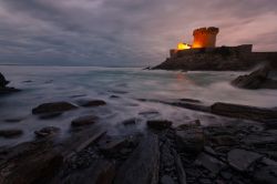 Una piccola fortezza illuminata di notte a Socoa nella baia di Donibane Lohitzune a Saint-Jean-de-Luz, Francia. In primo piano, l'Oceano Atlantico.

