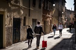 Gente a passeggio in un vicolo del centro storico di Piombino, Toscana - © robertonencini / Shutterstock.com
