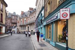 Gente a passeggio in una strada di Rennes, Francia. Sullo sfondo, una tipica casa a graticcio.
