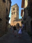 Gente a passeggio nel centro storico di Ainsa con il campanile sullo sfondo, Pirenei, Spagna. Ancora oggi le stradicciole e gli antichi edifici di questo borgo spagnolo raccontano le storie ...