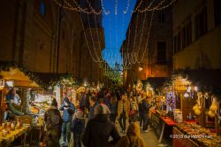 Gente a passeggio nel centro storico di Montepulciano, Siena, by night, durante il periodo dell'Avvento.
