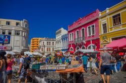 Gente a passeggio per il mercato locale di Curitiba, Brasile. Sullo sfondo le tipiche case dalle facciate variopinte - © Fotos593 / Shutterstock.com