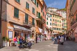 Gente a spasso per Riomaggiore, La Spezia, Liguria. Il villaggio è uno dei cinque famosi paesi costieri che costituiscono il Parco Nazionale delle Cinque Terre - © Patryk Kosmider ...