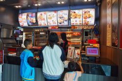 Gente al ristorante KFC (Kentucky Fried Chicken) nella città di Songkhla, Thailandia, in attesa di ordinare pollo  - © Waridsara Pitakpon / Shutterstock.com