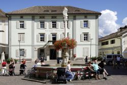 Gente di fronte al Municipio di Caldaro, Trentino Alto Adige. Nella piazza del mercato, proprio davanti al Rathaus, si trova la fontana di Maria - © Peter Probst / Shutterstock.com