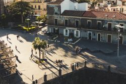 Gente in Piazza Castello a Aci Castello, provincia di Catania, Sicilia. Una suggestiva veduta della principale piazza cittadina dalla terrazza del castello normanno - © giuseppelombardo ...