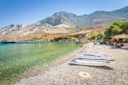 Gente in relax in una spiaggia di ciottoli sull'isola di Kalymnos, Grecia - © Tom Jastram / Shutterstock.com