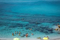 Gente in relax nell'acqua cristallina di San Giovanni di Sinis, Cabras, Sardegna. Un tempo borgo di pescatori, San Giovanni di Sinis è oggi una rinomata località balneare - Jana ...