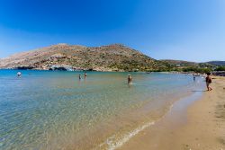 Gente in relax sulla spiaggia di Galissas a Syros, Grecia: questo tratto di costa è uno dei pochi sabbiosi dell'intera isola - © Nick Pavlakis / Shutterstock.com