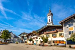 Gente in relax sulle panchine di una strada di Garmisch-Partenkirche, Germania.  