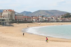 Gente in spiaggia a Saint-Jean-de-Luz, Francia. Questa celebre località balneare della costa basca è nota anche per la storia e il patrimonio architettonico.
