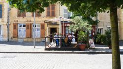 Gente in un caffé all'aperto in Place du Chateau vicino al castello di Sedan, Francia, in estate - © vvoe / Shutterstock.com