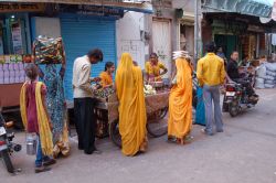 Gente in una strada di Udaipur, Rajasthan, India. Donne con gli abiti colorati fanno shopping in una bancarella lungo una via del centro - © CarGe / Shutterstock.com