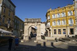 Gente passeggia sotto l'arco dei Sergi a Pola, Croazia - © dejan_k / Shutterstock.com