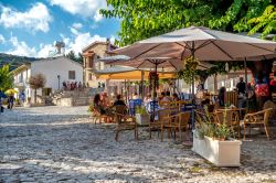 Gente seduta in un caffé all'aperto nel villaggio di Omodos, Cipro - © kirill_makarov / Shutterstock.com