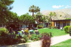 Gente seduta in un giardino davanti ad una casa a Palm Springs, California.
