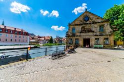 Gente seduta su una panchina lungo il fiume a Bamberga, Germania - © sunfun / Shutterstock.com