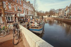 Gente su una barca trasformata in ristorante su un canale di Den Haag, Olanda, all'ora di pranzo - © Radiokafka / Shutterstock.com
