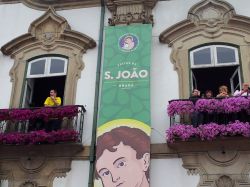Gente sui balconi assiste alla sfilata di Sao Joao nella cittadina di Braga, Portogallo. 
