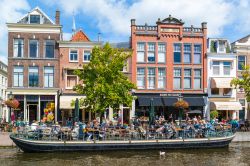 Gente sulla terrazza esterna di un cafè nel centro di Leiden, Olanda. Siamo lungo il canale New Rhine su cui si affacciano edifici antichi - © TasfotoNL / Shutterstock.com
