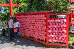 Giapponesi al santuario di Sanko Inari nel castello di Inuyama. Una parete di cuori in legno appesi vicino all'ingresso  - © Takashi Images / Shutterstock.com