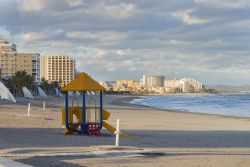 Giochi per i bambini sulla spiaggia di Morro de Gos a Oropesa del Mar, Spagna. Sullo sfondo i palazzi moderni che si affacciano sul lungomare di questa ridente città della Comunità ...