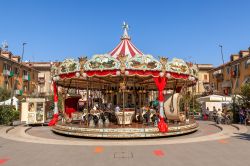 Giostre in piazza ad Alba, Piemonte, Italia. Sono il divertimento dei più piccoli ma anche degli adulti che li accompagnano: le tradizionali giostre antiche in legno con cavalli e carrozze ...