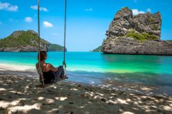 Una giovane ragazza seduta su un'altalena all'Ang Thong National Marine Park, Thailandia. Un vero e proprio paradiso per gli amanti del relax e della natura rigogliosa.

