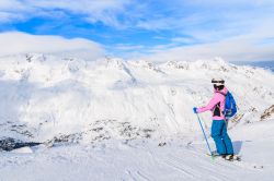 Una giovane sciatrice osserva il panorama innevato delle montagne a Obergurgl-Hochgurgl, Austria. Con i suoi 1930 metri di altezza, questa località è il paese più alto del ...