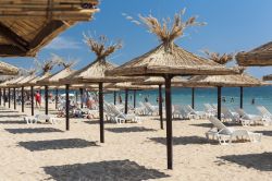 Golden Sands vicino a Varna, Bulgaria. Ombrelloni di paglia e sdraio sulla spiaggia di questa località estiva del Mar Nero.
