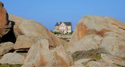 Grandi rocce di granito sulla costa di Ploumanac'h (Francia). Sullo sfondo, una graziosa casa immersa nella natura più autentica di questo territorio 
