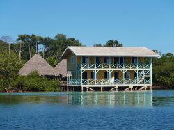 Un caratteristico hotel tropicale su palafitte nel mare dei Caraibi, Bocas del Toro, Panama. Da qui si può ammirare un panorama spettacolare sull'oceano e sulla natura che circonda ...