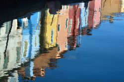 I colori vivaci di Burano riflessi nelle acque dei canali - uno dei principali simboli dell'isola di Burano, perla della Laguna di Venezia, è il colore. Ogni casa di Burano è ...