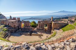 I resti del teatro greco di Taormina con l'Etna sullo sfondo, Sicilia. Scavato nella roccia, ha un diametro massimo di 109 metri e un'altezza di circa 20 metri. Il fondo della scena, ...