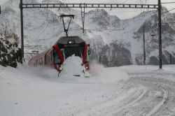 Il Bernina Express in arrivo alla stazione Alp Grum nei pressi di Poschiavo, Svizzera: una suggestiva veduta invernale con la neve - © Fed Photography / Shutterstock.com