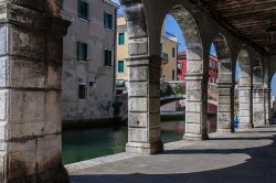 Il canale di Chioggia visto da sotto le arcate dei palazzi antichi, Veneto, Italia.

