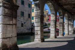 Il canale di Chioggia visto da sotto le arcate dei palazzi antichi, Veneto, Italia.

