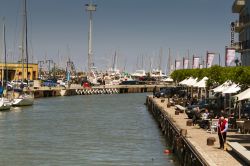 Il canale di Gabicce Mare al porto, Marche. Sulla sponda destra, gente seduta ai tavolini di un caffé-ristorante - © StockMySelf / Shutterstock.com